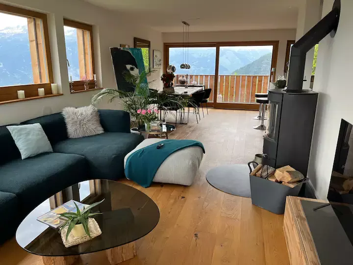 Grand séjour avec poêle à bois, canapé d’angle et vue sur les montagnes — Appartement contemporain d’exception, Vercorin