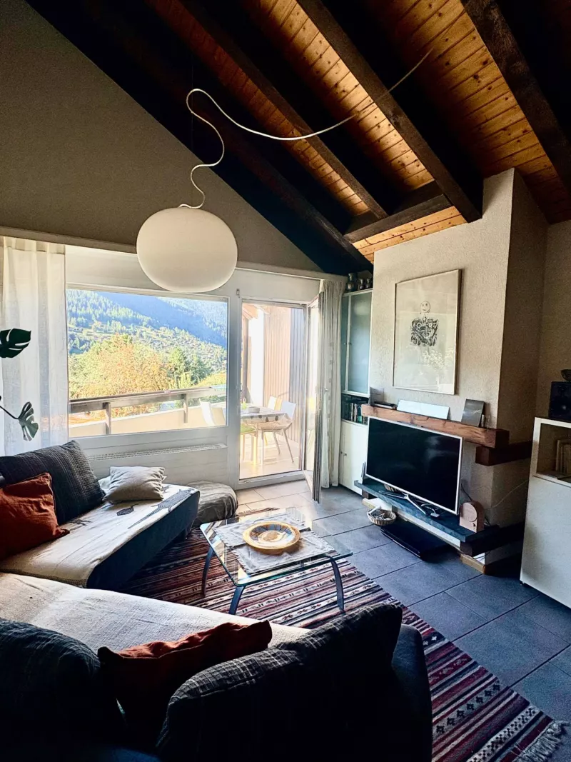 Séjour mansardé avec baie vitrée ouvrant sur le balcon et la vue — Appartement duplex avec balcon, Vercorin