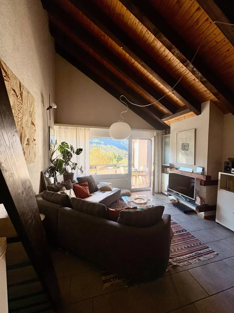 Salon du duplex à Vercorin avec canapé, télévision et accès au balcon